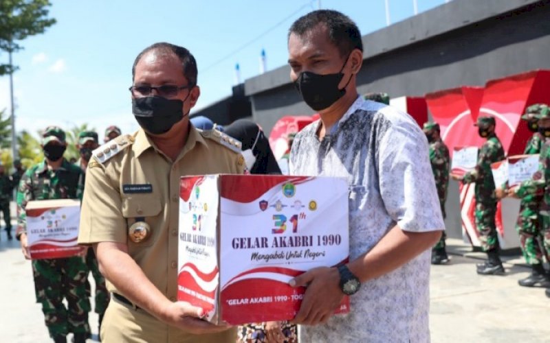 BERI BANTUAN. Wali Kota Makassar, Moh Ramdhan Pomanto, menyerahkan bantuan paket sembako di sela-sela kegiatan vaksinasi dan baksos yang diadakan alumni Akabri 1990 di Anjungan Pantai Losari Makassar, Selasa (26/10/2021). foto: istimewa