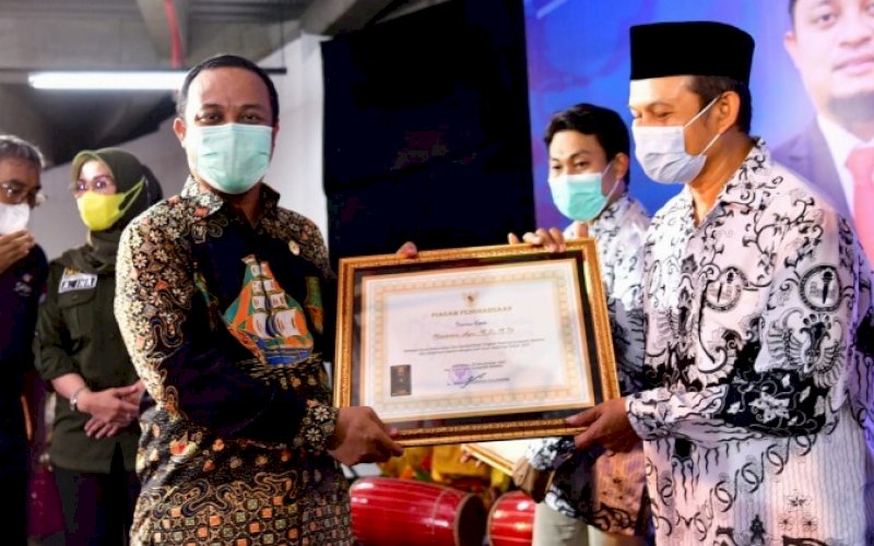 PENGHARGAAN. Plt Gubernur Sulsel, Andi Sudirman Sulaiman, menyerahkan penghargaan kepada tenaga pendidik dan kependidikan pada peringatan Hari Guru Nasional Tingkat Provinsi Sulsel di Mal Nipah Makassar, Kamis (25/11/2021). foto: istimewa