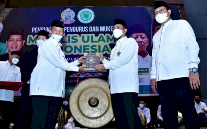 PENYERAHAN. Plt Gubernur Sulsel Andi Sudirman Sulaiman (kanan) menyerahkan Al Qur&rsquo;an 2.000 mushaf secara simbolis kepada Ketua MUI Sulsel AG KH Najamuddin Abd Safa pada Pengukuhan Pengurus MUI Sulsel Masa Khidmat 2021-2026 di Four Points by Sheraton Hotel Makassar, Minggu (31/10/2021). foto: istimewa