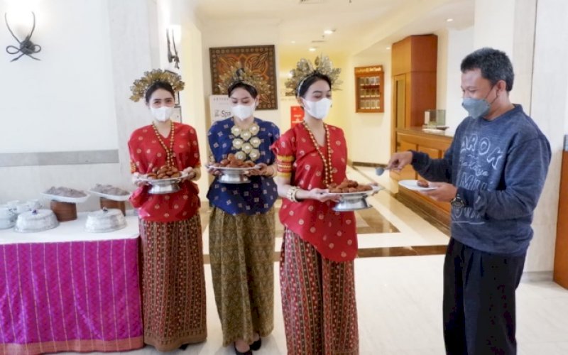 SAMBUTAN. Staf Aryaduta Makassar menawarkan taripang dan sarabba saat menyambut tamu hotel dalam rangka ikut merayakan HUT Kota Makassar ke-414, Selasa (9/11/2021). foto: istimewa