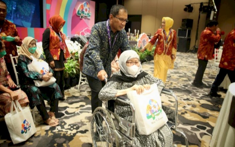 PEDULI. Wali Kota Makassar, Moh Ramdhan Pomanto, mendorong kursi roda salah seorang mantan guru SMAN 1 Makassar pada reuni alumni Smansa Makassar angkatan 1981 di Hotel The Rinra Makassar, Sabtu Malam (20/11/2021). foto: istimewa