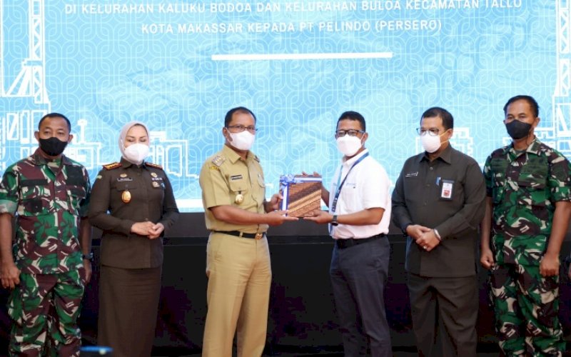 PENYERAHAN. Wali Kota Makassar, Moh Ramdhan Pomanto, secara resmi menyerahkan SK Wali Kota nomor 2037/59171/tahun 2021 tanggal 15 November 2021 tentang Penetapan Lokasi Pembangunan Akses Jalan Tol Makassar New Port (MNP) kepada PT Pelindo (Persero), Senin (22/11/2021). foto: istimewa