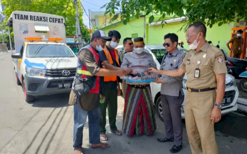 BERBAGI. Direktur Utama Perumda Parkir Makassar Raya, Irham Syah Gaffar (tengah), turun langsung membagikan kue taripang kepada para juru parkir di sejumlah titik, Selasa (9/11/2021). foto: istimewa