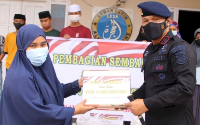 BERBAGI. Komandan Batalyon C Pelopor Satbrimob Polda Sulsel, Kompol Nur Ichsan, menyerahkan paket sembako kepada warga kurang mampu di Kabupaten Bone, Sabtu (6/11/2021). foto: istimewa
