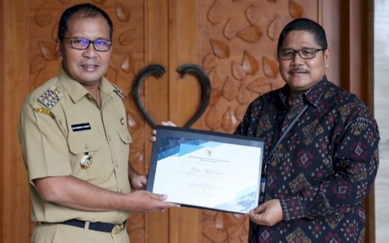 TERIMA PIAGAM. Wali Kota Makassar Moh Ramdhan Pomanto menerima piagam penghargaan dari Bank Indonesia yang diserahkan Kepala Perwakilan Bank Indonesia Wilayah Sulsel Causa Iman Karanadi di kediaman pribadinya, Jl Amirullah, Kota Makassar, Selasa (28/12/2021). foto: istimewa 
