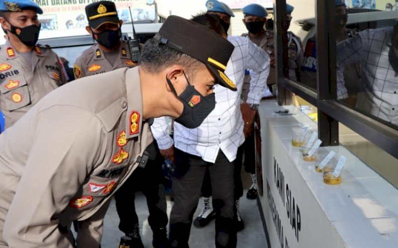 TES URINE. Kapolres Palopo, AKBP Muh Yusuf Usman, mengamati sampel hasil tes urine bawahannya, Kamis (20/1/2022). foto: istimewa