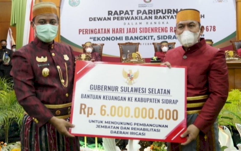 BANTUAN KEUANGAN. Plt Gubernur Sulsel Andi Sudirman menyerahkan bantuan keuangan kepada Bupati Sidrap Dollah Mando pada Rapat Paripurna DPRD dalam rangka Hari Jadi Kabupaten Sidrap ke-678 dengan tema 'Ekonomi Bangkit, Sidrap Kuat', Jumat (18/2/2022). foto: istimewa