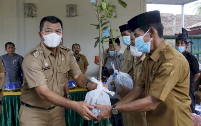 PENYERAHAN. Bupati Bulukumba, Andi Muchtar Ali Yusuf, menyerahkan secara simbolis bantuan bibit dari program Tanggung Jawab Sosial dan Lingkungan (TJSL) perusahaannya untuk warga di Desa Tambangan dan Desa Tana Towa usai menghadiri Musrenbang Tingkat Kecamatan Kajang, Selasa (8/2/2022). foto: istimewa