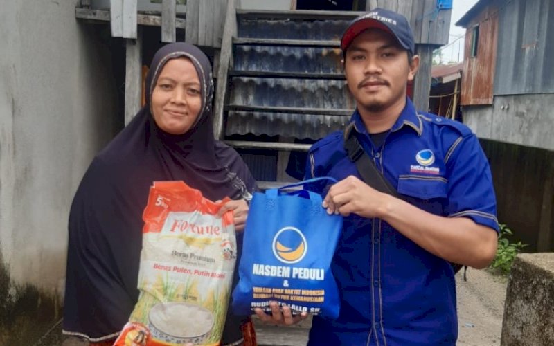 BAGI BANTUAN. Tim Ketua DPRD Kota Makassar, Rudianto Lallo, membagikan paket sembako kepada warga di Pulau Kodingareng, Kecamatan Sangkarrang, Kota Makassar, Sabtu (12/2/2022). foto: istimewa