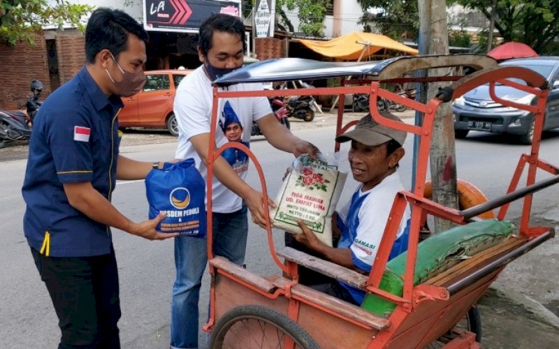 BERBAGI. Tim Ketua DPRD Kota Makassar, Rudianto Lallo, membagikan sembako kepada warga kurang mampu, Jumat (18/2/2022). foto: istimewa