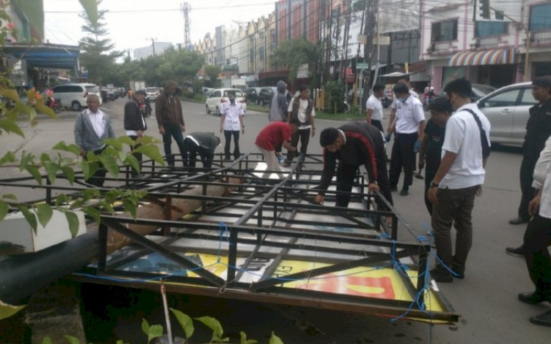 PENERTIBAN. Tim Bapenda Kota Makassar melakukan penertiban dan pembersihan beberapa reklame liar dan bando di dua titik jalan protokol Kota Makassar, di persimpangan Jl Adhyaksa-Pengayoman, Rabu (23/3/2022). foto: istimewa