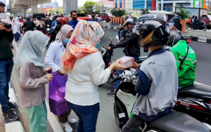 JUMAT BERKAH. Ikawan DPRD Kota Makassar membagikan makanan siap santap kepada sejumlah pengemudi ojol dan bentor di sepanjang Jl AP Pettarani, Kota Makassar, Jumat (25/3/2022). foto: istimewa