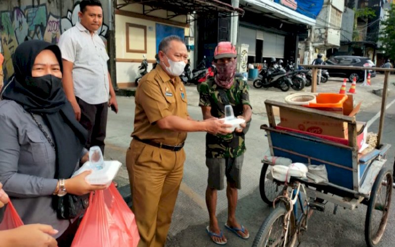 BERBAGI TAKJIL. Kepala Dinas Pertanahan Kota Makassar, Ahmad Namsum, ikut langsung membagikan takjil buka puasa kepada pengguna jalan di sekitar Jl Nusantara, Kota Makassar, Selasa (19/4/2022). foto: istimewa 