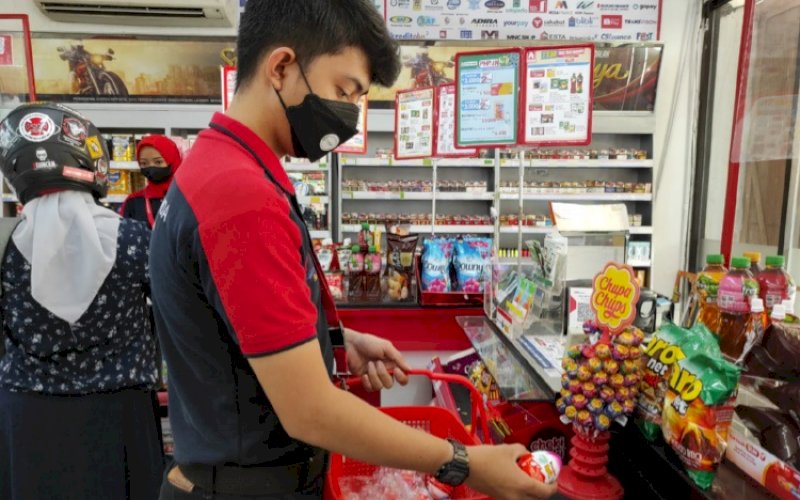 PENARIKAN. Salah seorang petugas Alfamidi mengambil produk Kinderjoy. Mengikuti anjuran BPOM RI, Alfamidi akan menarik semua produk Kinderjoy dari pasaran. foto: istimewa