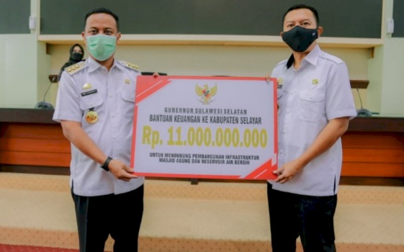 PENYERAHAN. Gubernur Sulsel Andi Sudirman Sulaiman (kiri) menyerahkan bantuan keuangan pemerintah daerah kepada Kabupaten Kepulauan Selayar yang diterima Bupati Selayar Muh Basli Ali di Ruang Rapat Pimpinan Kantor Gubernur, Rabu (27/4/2022). foto: istimewa 
