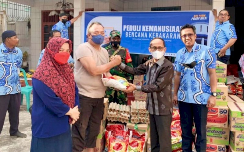 SERAHKAN BANTUAN. Penjabat Direktur Teknik Perumda Air Minum Kota Makassar, Arifuddin Hamarung (kanan), menyerahkan bantuan untuk korban kebakaran yang terjadi di Jl Veteran Selatan, tepatnya di Asrama Polisi Perintis, Kota Makassar di Posko Induk Korban Kebakaran di Kelurahan Mandala, Kecamatan Mamajang, Kota Makassar, Kamis (21/4/2022). foto: istimewa