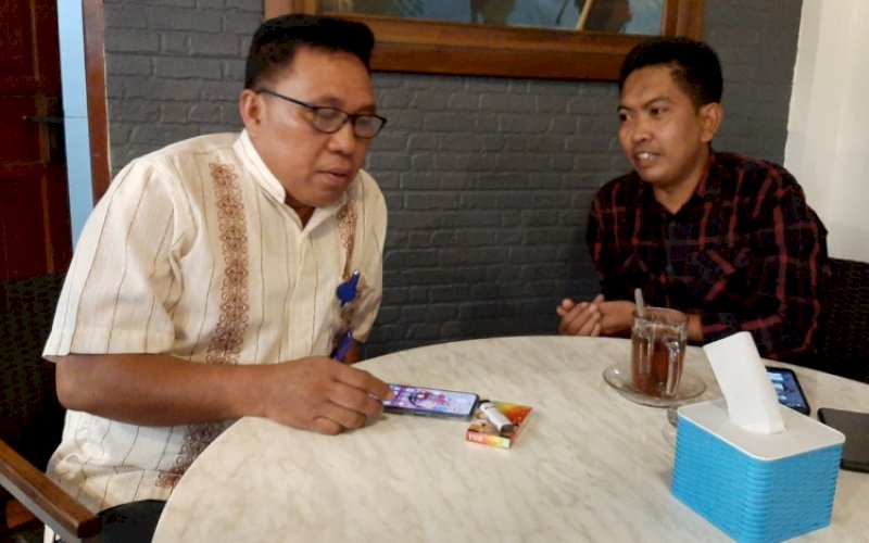BINCANG SANTAI. Humas PD Parkir Kota Makassar Asrul B (kanan) bincang santai dengan Kabag Umum Asraruddin M di sela-sela memberikan keterangan kepada media di salah satu cafe di Makassar, Jumat (1/3/2022). foto: doelbeckz/pluz.id&nbsp;