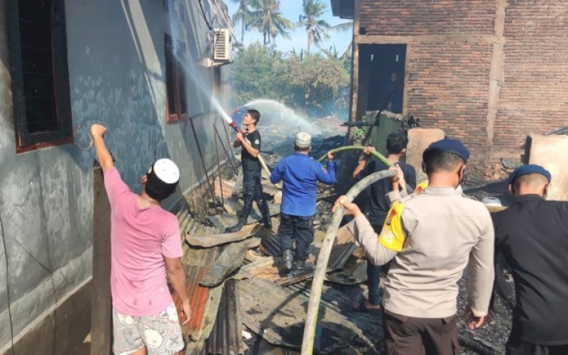 PADAMKAN API. Personel Brimob Bone bersama warga membantu memadamkan api saat terjadi kebakaran rumah di Kelurahan Panyula, Kecamatan Tanete Riattang Timur, Kabupaten Bone, Minggu (10/4/2022) siang. foto: istimewa