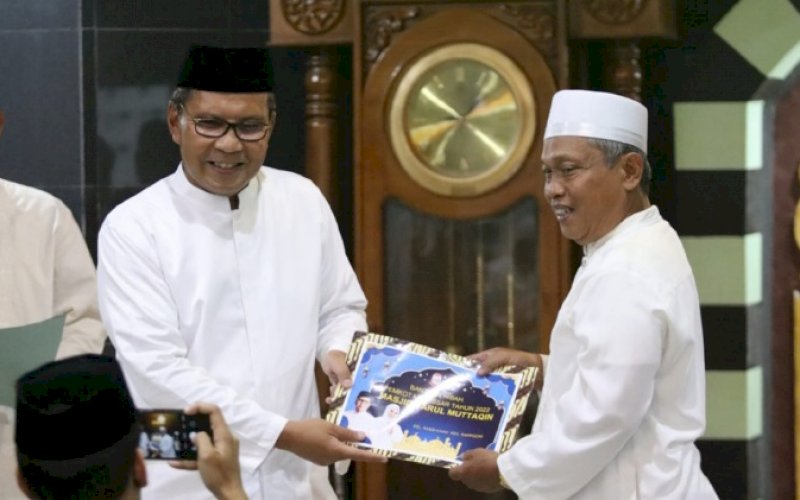 BERI BANTUAN. Wali Kota Makassar, Moh Ramdhan Pomanto (kiri), menyerahkan bantuan hibah kepada pengurus Masjid Darul Muttaqin, Kompleks Puri Taman Sari, Jl Toddopuli IV, Kelurahan Kassi-kassi, Kecamatan Rappocini, Kota Makassar, Senin (11/4/2022). foto: istimewa