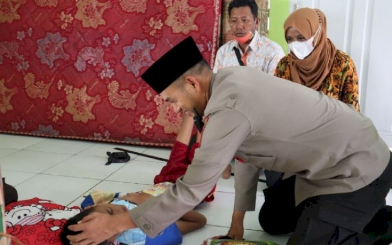PEDULI. Kapolres Palopo, AKBP Muh Yusuf Usman, saat menjenguk dan memberikan bantuan&nbsp;kepada anak yang mengalami lumpuh layuh, Jumat (14/4/2022). foto: istimewa