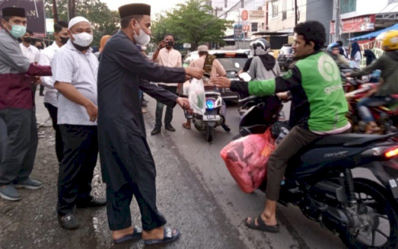 BERBAGI. Ketua Umum IKA SMAN 6 Makassar, Rudianto Lallo, turun langsung membagikan ratusan takjil gratis kepada masyarakat yang melintas di Jl Andi Djemma, Kota Makassar, Minggu (10/4/2022) sore. foto: istimewa