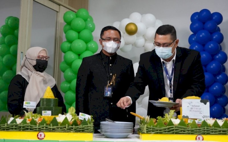 HUT PEGADAIAN. Pimpinan Wilayah Kanwil VI PT Pegadaian Makassar, Zulfan Adam (kanan), memotong tumpeng sebagai peringatan HUT Pegadaian ke-121. foto: istimewa