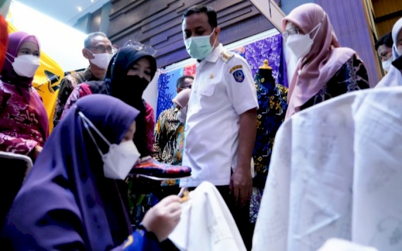 MEMBATIK. Gubernur Sulsel Andi Sudirman Sulaiman menyaksikan Bunda PAUD Sulsel Naoemi Octarina membatik saat meresmikan Pameran Media Pembelajaran SMK yang berlangsung di Hotel Four Pointa by Sheraton Makassar, Rabu (18/5/2022). foto: istimewa