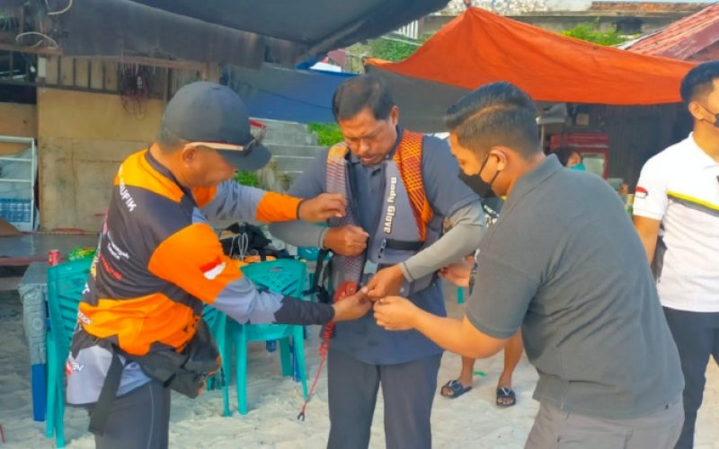 PERSIAPAN. Bupati Bulukumba Andi Muchtar Ali Yusuf memasangkan pelampung kepada Kapolda Sulsel Irjen Pol Nana Sudjana sebelum bermain jetski di Pantai Tanjung Bira, Desa Bira, Kecamatan Bonto Bahari, Kabupaten Bulukumba, Sabtu (21/5/2022). foto: istimewa