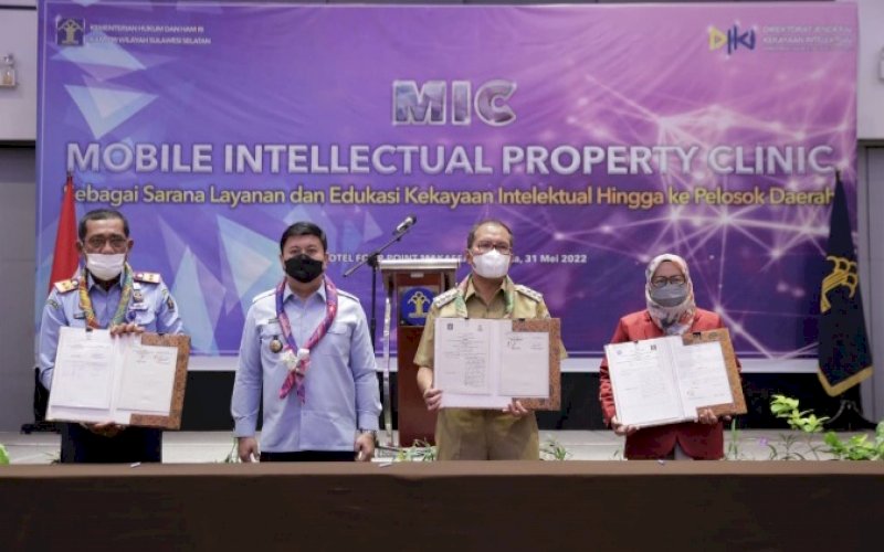 KERJA SAMA. Wali Kota Makassar, Moh Ramdhan Pomanto (kedua kanan), memperlihatkan berkas kerja sama bidang kekayaan intelektual dengan Kantor Wilayah Kemenkumham Sulsel di Four Points By Sheraton Hotel Makassar, Selasa (31/5/2022). foto: istimewa