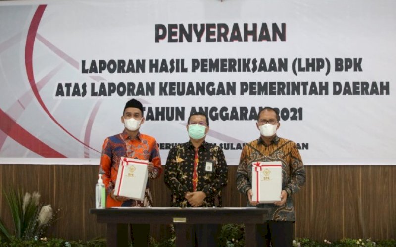 PENYERAHAN LHP. Kepala BPK Perwakilan Sulsel Paula Henry Simatupang (tengah) diapit Wali Kota Makassar Moh Ramdhan Pomanto (kanan) dan Ketua DPRD Kota Makassar Rudianto Lallo saat Penyerahan Laporan Hasil Pemeriksaan (LHP) BPK atas Laporan Keuangan Pemerintah Daerah Tahun Anggaran 2021 di Makassar, Jumat (20/5/2022). foto: istimewa