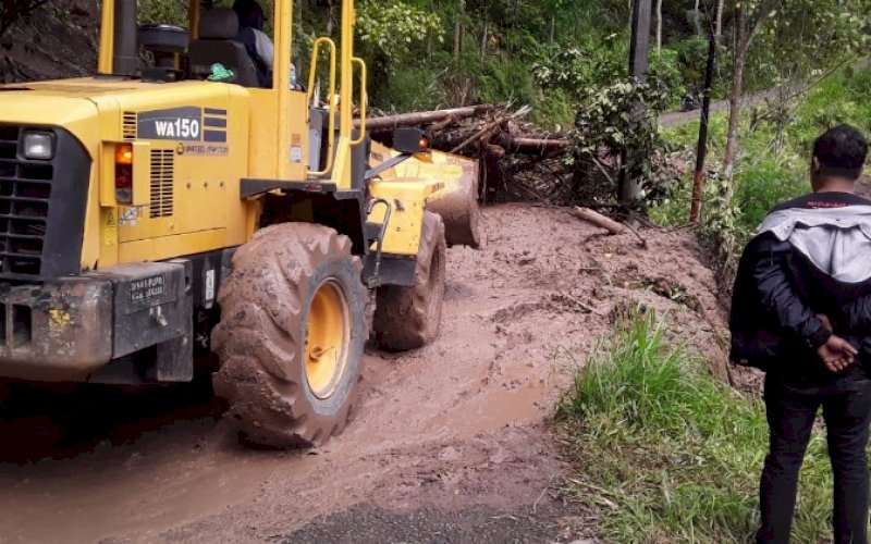PEMBERSIHAN. Dinas PUTR Provinsi Sulsel menurunkan alat berat untuk membersihkan material longsor yang menutupi ruas jalan batas Gowa-Tondong di Kabupaten Sinjai. foto: istimewa