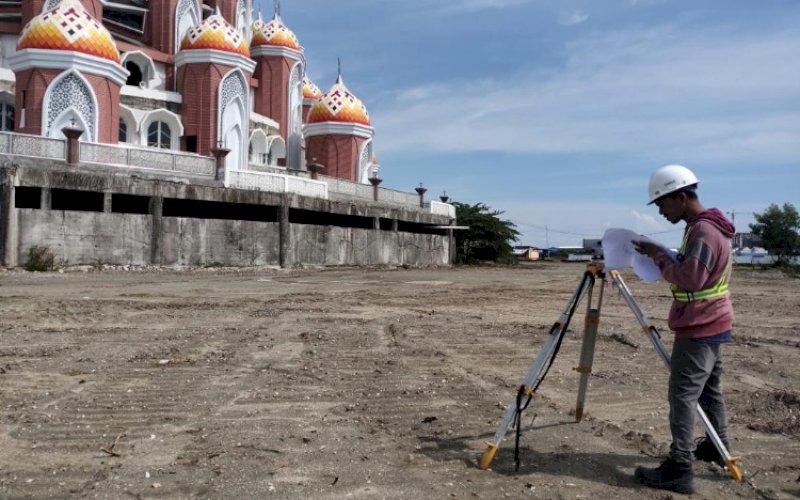 PEMBANGUNAN. Petugas melakukan pengukuran lahan pada lanjutan pembangunan Masjid 99 Kubah Asmaul Husna yang berlokasi di kawasan Center Point of Indonesia (CPI) Makassar, Jumat (27/5/2022). foto: istimewa
