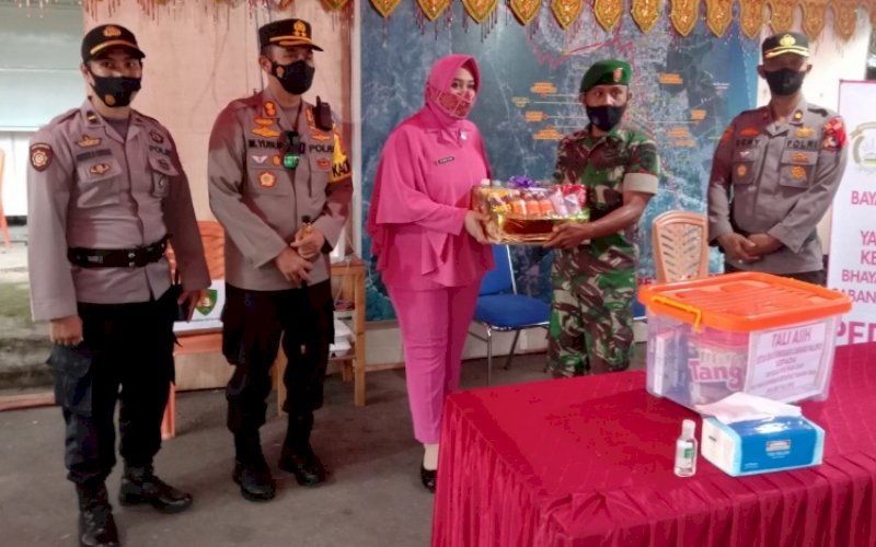 PENYERAHAN BINGKISAN. Ketua Bhayangkari Cabang Palopo Denny Yusuf didampingi Kapolres Palopo AKBP Muh Yusuf Usman menyerahkan bingkisan kepada personel yang bertugas di Pos Pengamanan dan Pelayanan Operasi Ketupat Palopo 2022 di wilayah hukum Polres Palopo. foto: istimewa