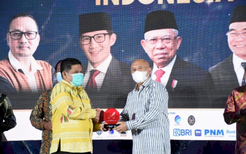PENYERAHAN. Menteri Koperasi dan UKM RI Teten Masduki (kanan) menyerahkan penghargaan Merdeka Award kepada Diskominfo-SP Sulsel Amson Padolo di Jakarta, Kamis (23/6/2022). foto: istimewa