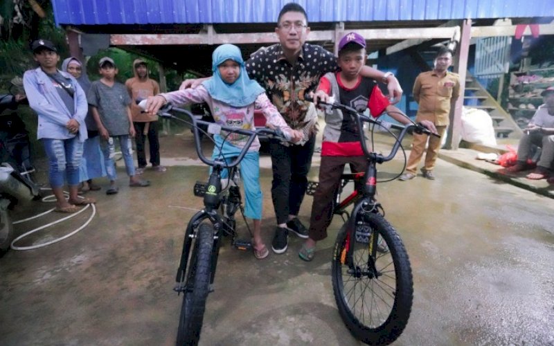 BANTUAN SEPEDA. Gubernur Sulsel, Andi Sudirman Sulaiman, mengirimkan tim ke Desa Tapong, Kecamatan Tellu Limpoe, Kabupaten Bone untuk memberikan bantuan sepeda kepada anak SD bersaudara yang berjalan kaki sejauh 7 Km dan membawa parang untuk ke sekolah. foto: istimewa