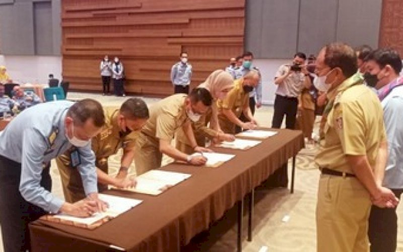 MOU. Kepala Balitbangda Kota Makassar Andi Bukti Djufrie (kedua kiri) disaksikan Wali Kota Makassar Moh Ramdhan Pomanto menandatangani Memorandum of Understanding (MoU) bersama Kantor Wilayah Kementerian Hukum dan HAM (Kemenkumham) Sulsel di Hotel Four Points by Sheraton Makassar, Selasa (31/5/2022). foto: istimewa