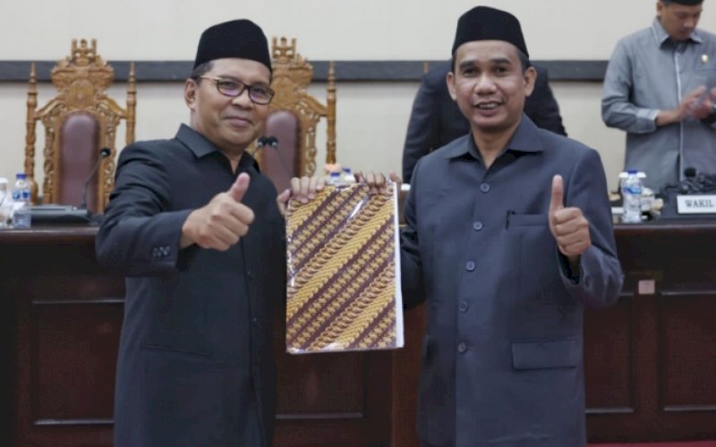 PENYERAHAN. Ketua DPRD Kota Makassar Rudianto Lallo (kanan) menyerahkan keputusan DPRD Kota Makassar terkait Ranperda Pertanggungjawaban Pelaksanaan APBD 2021 kepada Wali Kota Makassar Moh Ramdhan Pomanto di Ruang Rapat Paripurna DPRD Kota Makassar, Senin (27/6/2022). foto: istimewa