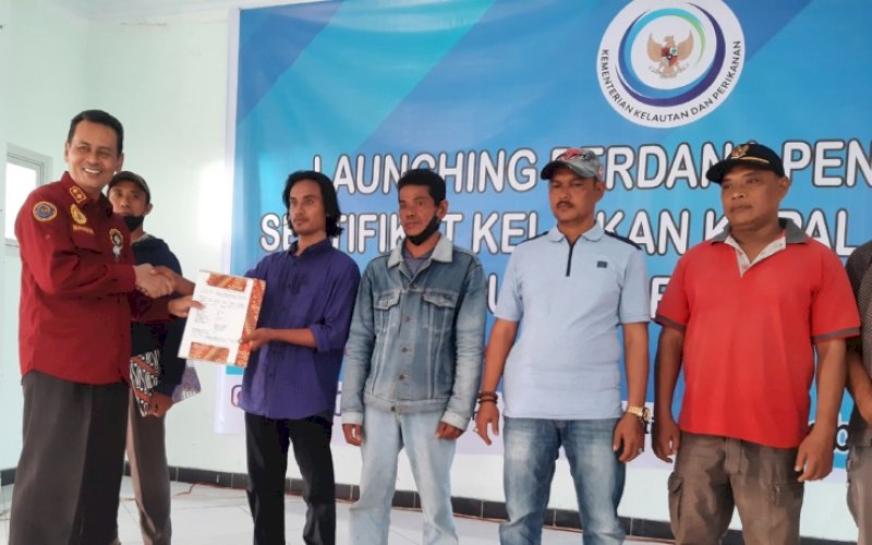 PENYERAHAN. Direktur Jenderal Perikanan Tangkap KKP dalam hal ini diwakili Direktur Kapal dan Alat Penangkapan Ikan, Mansur (kiri), menyerahkan sertifikat kelaikan kapal perikanan kepada pemilik kapal di Pelabuhan Perikanan Untia, Makassar, Sulsel, Rabu (15/6/2022). foto: doelbeckz/pluz.id