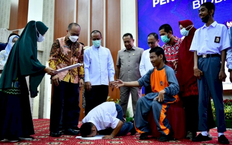 SUJUD SYUKUR. Seorang penyandang disabilitas sujud syukur usai menerima Kartu Tanda Penduduk Eletronik (e-KTP) dari Gubernur Sulsel, Andi Sudirman Sulaiman di Baruga Karaeng Pattingaloang, Jumat (29/7/2022). foto: istimewa