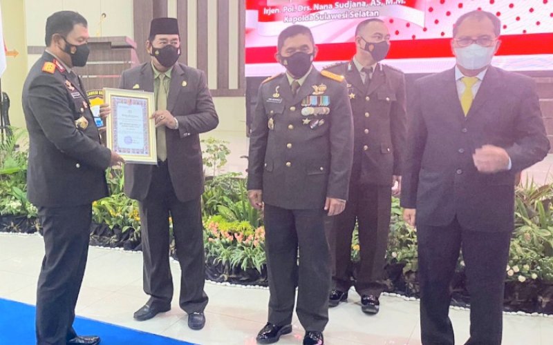 PENGHARGAAN. Kapolda Sulsel Irjen Pol Nana Sudjana (kiri) memberikan penghargaan kepada Gubernur Sulsel Andi Sudirman Sulaiman diwakili Sekda Provinsi Sulsel Abdul Hayat Gani di sela-sela upacara dan syukuran Hari Bhayangkara Ke-76 di Mapolda Sulsel, Selasa (5/7/2022). foto: istimewa