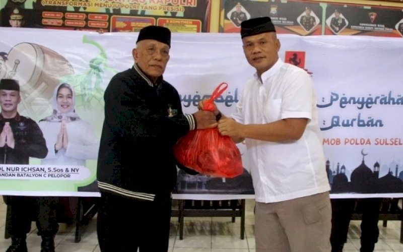 BERBAGI. Danyon C Pelopor Satbrimob Polda Sulsel, Kompol Nur Ichsan, menyerahkan daging sapi kurban kepada masyarakat yang berhak menerima, Minggu (10/7/2022). foto: istimewa