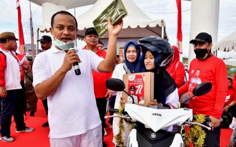 PENYERAHAN. Gubernur Sulsel, Andi Sudirman Sulaiman, menyerahkan hadiah utama Sulsel Anti Mager kepada pelajar asal SMK Negeri 1 Makassar bernama Ramlah di Kawasan Center Point of Indonesia (CPI) Makassar, Jumat (12/8/2022). foto: istimewa