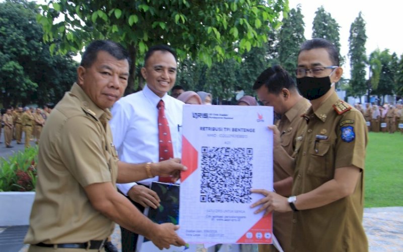 PENYERAHAN. Bulukumba, Andi Muchtar Ali Yusuf, menyerahkan secara simbolis kode batang (Barcode) QRIS kepada para Organisasi Perangkat Daerah (OPD) pengelola pajak dan retribusi di sela-sela Apel Gabungan OPD, Senin (8/8/2022). foto: istimewa