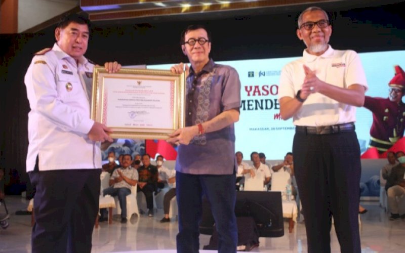 PENGHARGAAN. Menteri Hukum dan HAM RI Yasonna Laoly menyerahkan penghargaan kepada Sekda Provinsi Sulsel Abdul Hayat Gani di Kampus Universitas Negeri Makassar (UNM), Rabu (28/9/2022). foto: istimewa