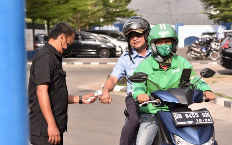 NAIK OJOL. Direktur Utama Perumda Air Minum Kota Makassar, Beni Iskandar, naik kendaraan Ojek Online (Ojol). foto: istimewa
