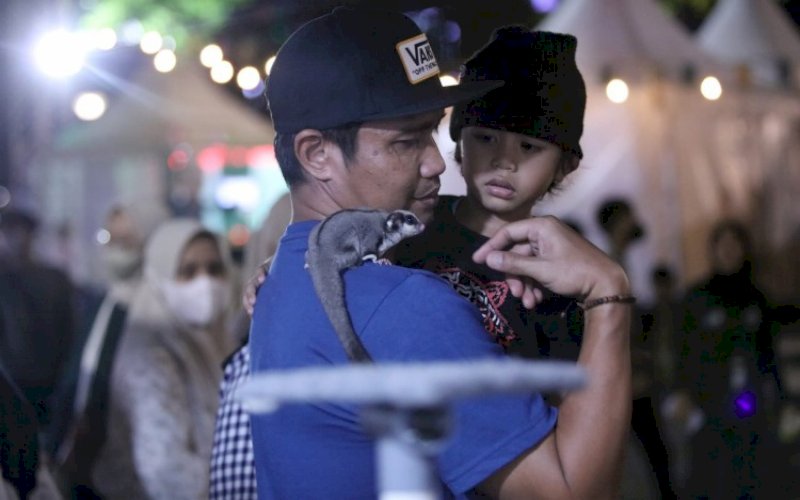 FAUNA. Pengunjung memperkenalkan satwa kepada anaknya di stan Fauna Makassar F8 di Anjungan Pantai Losari Makassar, Sabtu (10/9/2022). foto: istimewa