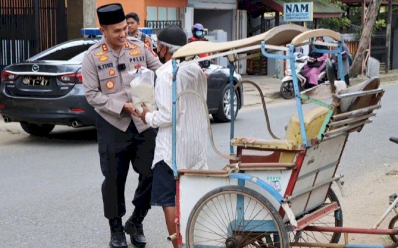 PEDULI. Kapolres Palopo, AKBP Muh Yusuf Usman, menyalurkan beras kepada salah seorang tukang becak di Kota Palopo, Senin (12/9/2022). foto: istimewa