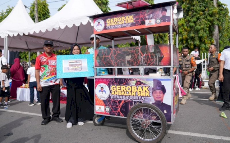 GEROBAK ANDALAN. Gubernur Sulsel, Andi Sudirman Sulaiman, menyerahkan satu unit gerobak Andalan SMK Tenaga Surya kepada Nirmayani, pedagang minuman tradisional yang berjualan di Lapangan Pemuda Bulukumba, Minggu (30/10/2022). foto: istimewa