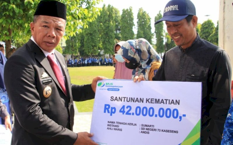 SANTUNAN KEMATIAN. Bupati Bulukumba, Andi Muchtar Ali Yusuf, menyerahkan santunan kematian di sela-sela upacara peringatan HKN Ke-58 di halaman Kantor Bupati Bulukumba, Senin (14/11/2022). foto: istimewa