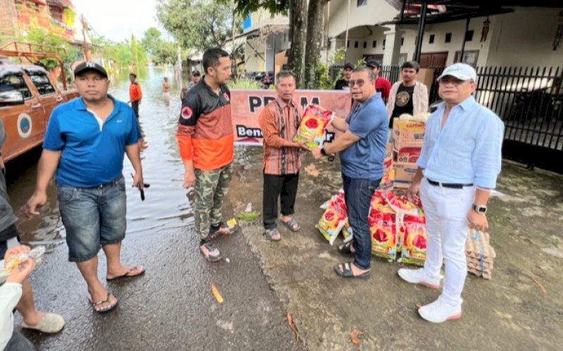 PEDULI. Direktur Teknik Perumda Air Minum Kota Makassar Asdar Ali disaksikan Direktur Utama Perumda Air Minum Kota Makassar Beni Iskandar menyerahkan bantuan kepada warga terdampak banjir, Sabtu (19/11/2022). foto: istimewa